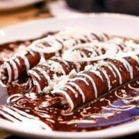 Enchiladas de mole poblano · 3 soft corn tortillas rolled and filled with choice of protein and cheese. Topped with signa...