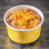 Side Refried Beans · Blend of black & pinto beans refried and topped with Tex-Mex sauce & cheese.