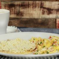 Huevos Pericos · Scrambled eggs with onions and tomatoes, arepa (corn cake) and hot chocolate or coffee.