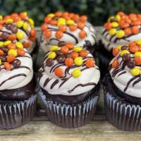 Peanut Butter Cup Cupcakes · Moist chocolate cake dipped in chocolate ganache and frosted in peanut butter Swiss buttercr...