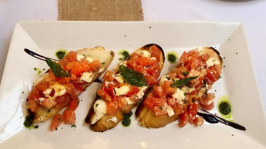 Brushetta with Mozzarella and Tomatoes · Freshly toasted bread topped with mozzarella tomato and basil.