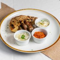 Cevapi · Balkan sausages served in pita bread with ajvar and onions. Add kajmak for an additional cha...