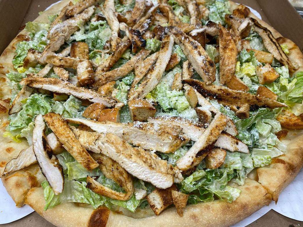 Grilled Chicken Caesar Pizza · Topped with grilled chicken strips, romaine lettuce, aged Romano cheese, and Caesar dressing.