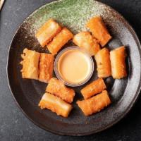 Kani Poppers · Mini kani pieces, tempura battered and deep-fried drizzled with sweet sauce.