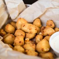 Wisconsin Cheese Curds  · White cheddar cheese curds lightly dusted and fried golden brown.