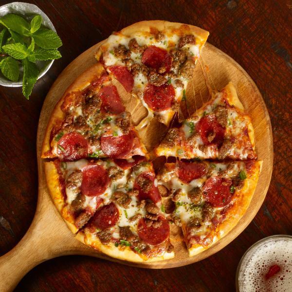 Meat-Eater Pizza · Thick Crust Pizza, Lightly Brushed with Honey Butter and Topped with Marinara Sauce, Italian Sausage, Pepperoni, Seasoned Hamburger, Roasted Green Onions, Mozzarella, and Parmesan Cheeses 