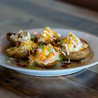 Potato Skins · Baked potato skins filled with smashed potatoes, topped with our signature queso, shredded c...