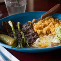 Carne Asada · Slices of flank steak, Served with beans and rice, onions, guacamole and tortillas.