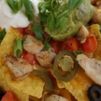 Chicken Nachos · Tortilla chips smothered with cheddar cheese, tomatoes, olives, onions, jalapeños, and chick...