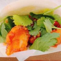 Korean Fried Chicken Bao · Crispy chicken tender, gojuchang sauce (spicy), sesame seeds, cucumber & cilantro
