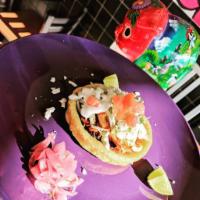 Sopes · Corn griddle cake topped with refried black beans, crema, cotija cheese, lettuce and tomato ...