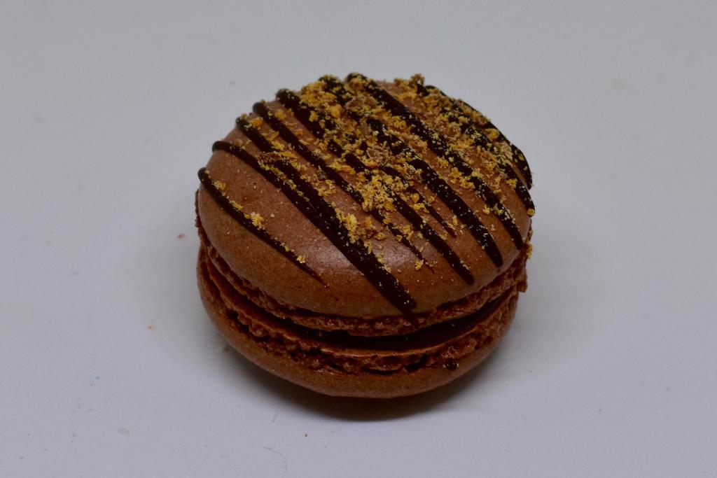 Butterfinger Macaron · Chocolate shells with butterfinger sprinkles and a butterfingers buttercream.