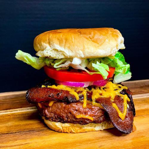 Banging Bacon Cheese Burger · Hickory smoke tempeh bacon, vegan cheese, lettuce, tomato, plant based burger, onion, vegan mayo on a toasted bun.