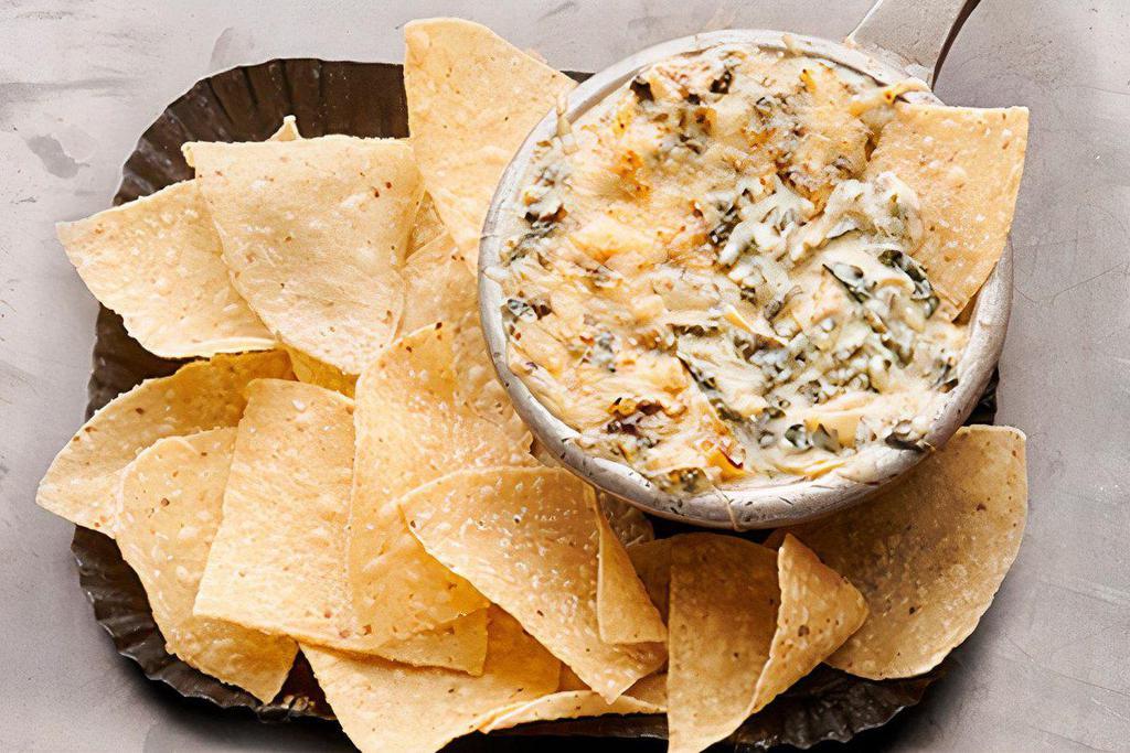 Spinach-Artichoke Dip  · Creamy white American and Asiago cheeses, spinach, grape tomatoes and roasted artichokes, topped with shredded Parmesan cheese. Served with garlic cheese toast 