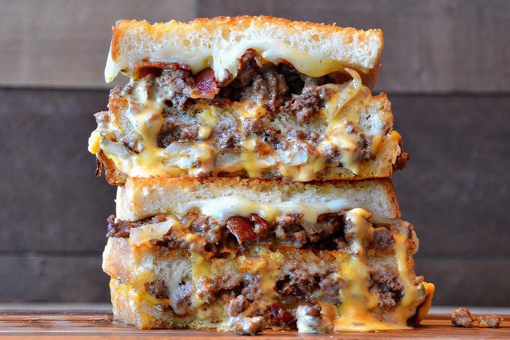 Double Bacon Burger Grilled Cheese · Crumbled burger meat topped with bacon, American and provolone cheese, caramelized onions, pickles and 1000 island dressing on Parmesan sourdough. 

