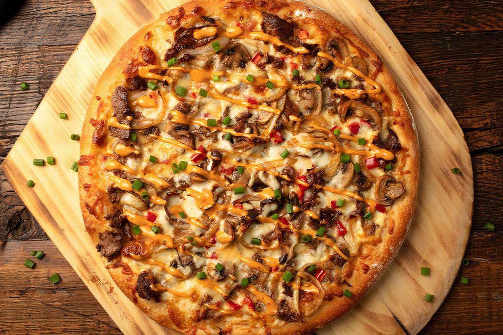 Philly Cheesesteak Pizza · Grilled sirloin and onions, Voodoo Ranger Queso, mozzarella cheese, red pepper and chipotle aioli 