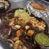 OXTAIL DINNER · Beef Oxtails Slow Simmered In A Delicious Brown Gravy Sauce. Served With Rice And Beans, Cab...