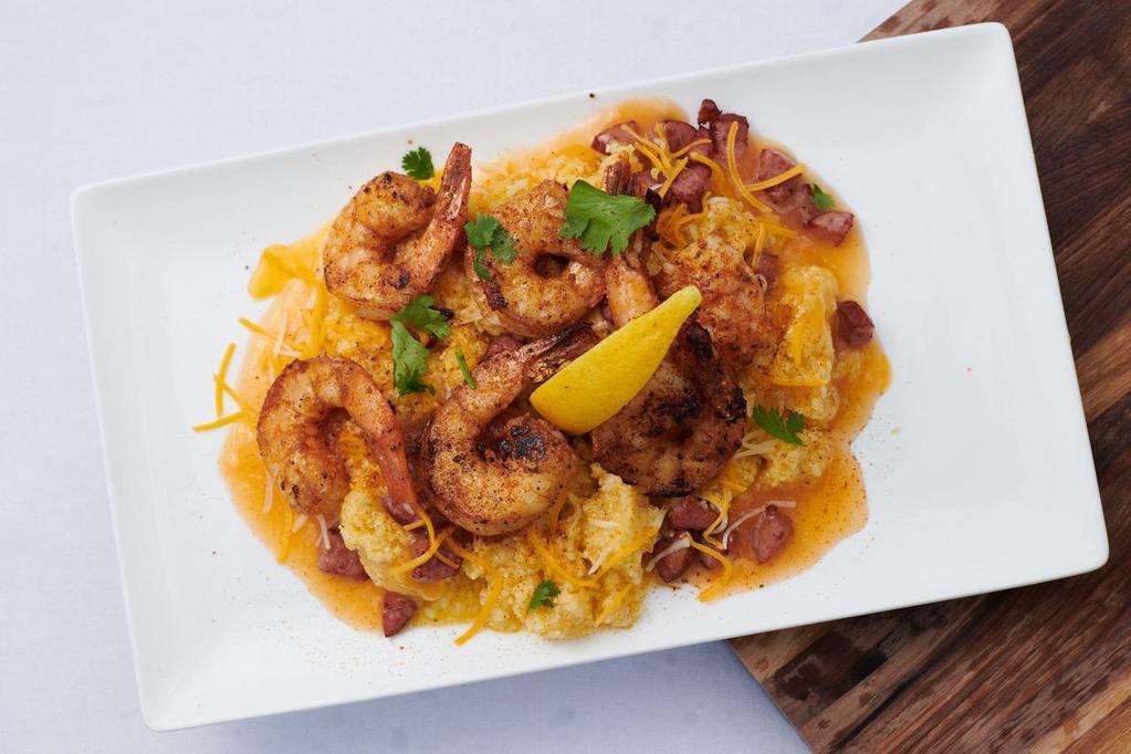 Shrimp and Grits · Marinated jumbo shrimp, creamy yellow stone ground grits smoked turkey sausage red peppers chives cheddar. Cajun butter or garlic butter sauce.
