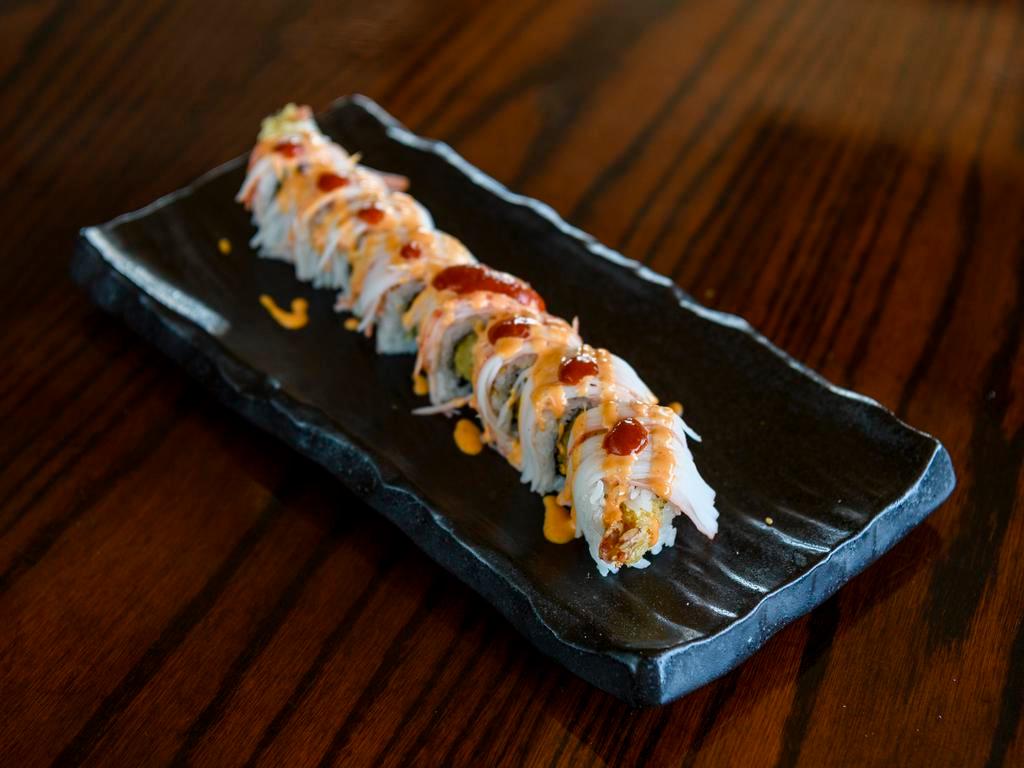 Spicy Cowboy Roll · Tempura shrimp and avocado, topped with crab, spicy mayo and sriracha chili sauce.