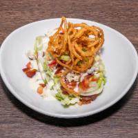 Wedge Salad · Topped with bleu cheese crumbles, tomato, bacon, tobacco onions, bleu cheese dressing.