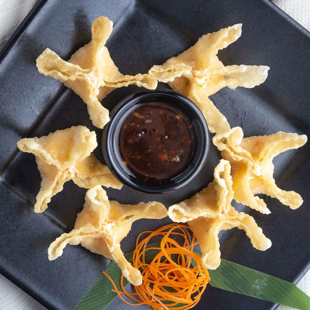 Crispy Crab Wontons · Golden wontons filled with crab and cream cheese, delicately seasoned and served with sweet chili dipping sauce.