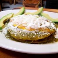Huevos Rancheros Verdes · 2 deep fried corn tortillas, re-fried pinto beans, 2 fried eggs bathed on a green tomatillo ...