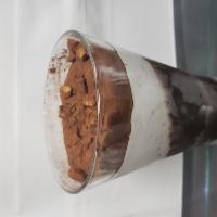Coppa Stracciatella · Frozen cream and chocolate sauce topped with cocoa and praline hazelnuts in glass 