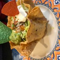 Fajita Taco Salad · Tortilla shaped bowl with a choice of steak or chicken. Served on a bed of fried onions and ...