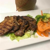Grilled Pork Chop · Marinated honey pork served with mixed vegetables, jasmine rice, and Thai spicy lime vinaigr...