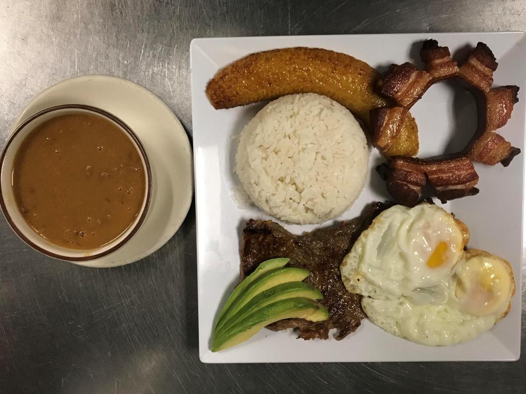 Bandeja Montanera · Carne, chicharron, ensalada, huevo, arroz, maduro y habichuela.

Rice, beans, fried pork skin, egg, salad, sweet plantain, meat.