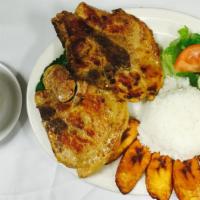 Chuleta de Cerdo a la Parrilla · Grilled pork chop with rice, fried sweet plantain, salad and beans