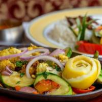 Fish Tikka · Chunks of fresh fish marinated in yogurt and herbs, cooked in a clay oven. Served with veget...