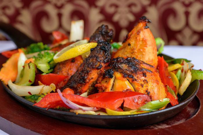 Tandoori Chicken · Spring chicken marinated in special marinade with freshly ground spices. Cooked in a clay oven. Served with vegetables and rice.