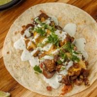 Texas Cheesesteak · Grilled fajita beef on a flour tortilla, mushrooms, jalapeños, red onions, serrano-cilantro ...