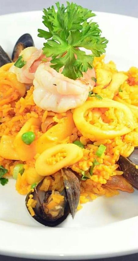 Arroz con Mariscos · Selected rice dancing in a hot pan along with fresh fruit of the sea, saffron and salsa criollo.