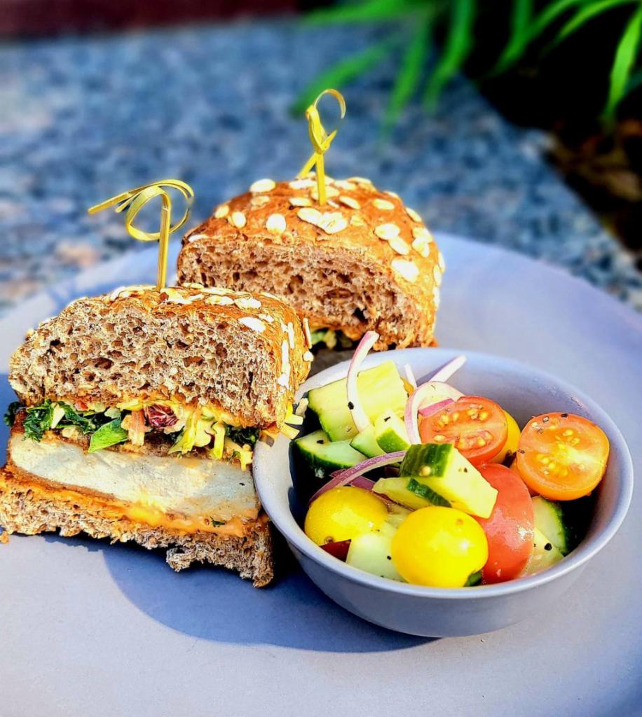 Crispy Sandwich · Toasted Sprouted oat Wheat Bun, breaded scallopini, power-blend coleslaw, Calabrian chili aioli served with a Tomato & Cucumber Salad (nf)