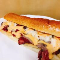 G1. Manhattan Combo · Grilled pastrami & corned beef, coleslaw, melted Swiss cheese, and Russian dressing on a toa...