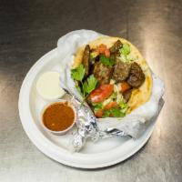 Halal Lamb Gyro Sandwich · Rolled pita bread stuffed with freshly grilled cutlets of lamb. It comes with lettuce, tomat...