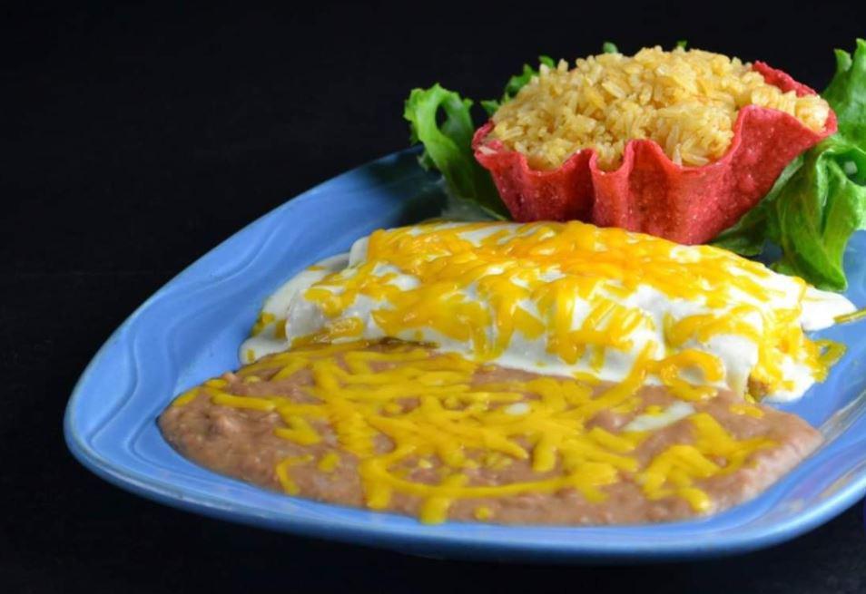 Enchiladas a la Crema · Enchiladas smothered with a rich, decadent cream sauce and cheddar cheese. Tastes best with chicken. Served with Mexican or white rice and choice of beans.