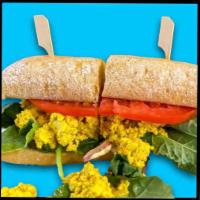 The Brekkie Sandwich · Golden Tofu Scramble Sandwich with greens, tomato, our Lemon Caper Aioli, and of course - Sa...