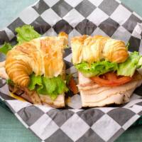 Croissant Club · Turkey, honey ham, bacon, Colby Jack cheese, honey mustard, lettuce and tomato on a croissant.