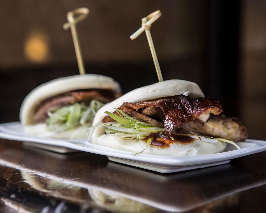Crispy Duck Steamed Buns · Duck with scallions and hoisin sauce inside a steamed bun. Includes two pieces.