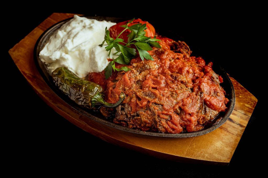 Iskender · Lamb gyro served over diced pita bread. Served with freshly made tomato sauce and yoghurt.