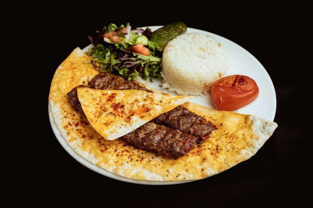 Lamb Adana Kebab · Ground lamb flavored with red bell peppers, slightly seasoned. Served with paprika and grilled on skewers. Served with rice and salad 