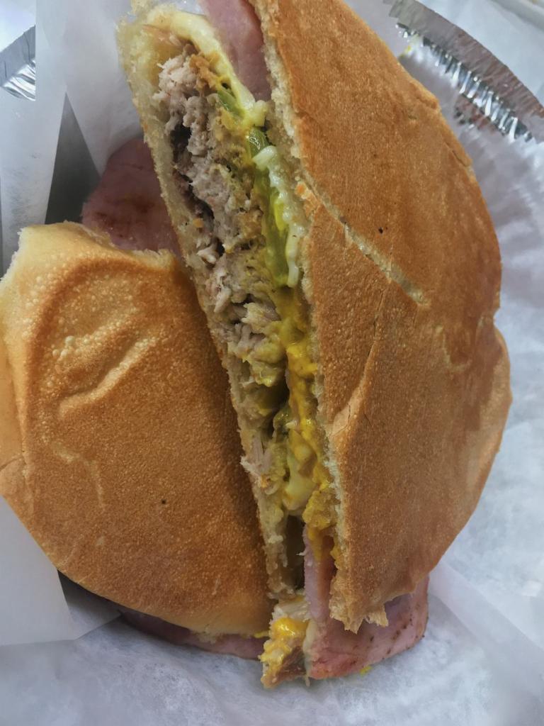 Sandwich Cubano · Roasted pork, Swiss cheese, pickles, and mustard.