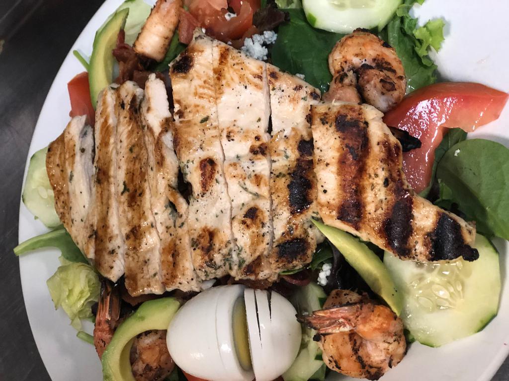 Cobb Salad · Grilled chicken breast, avocado, hardboiled egg, bacon, tomatoes, onions, and blue cheese crumbles. Choice of dressing.