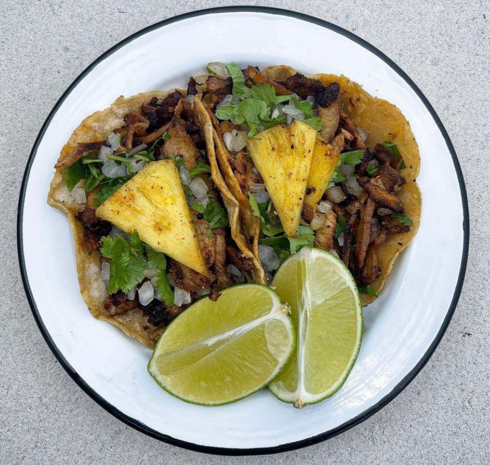 Al Pastor Taco · Marinated pork with onion, cilantro, and a slice of pineapple.
