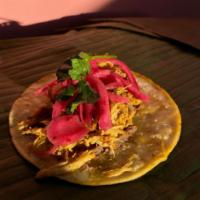 Cochinita Pibil Taco · Slow-roasted pork with a spread of refried beans and pickled onion.