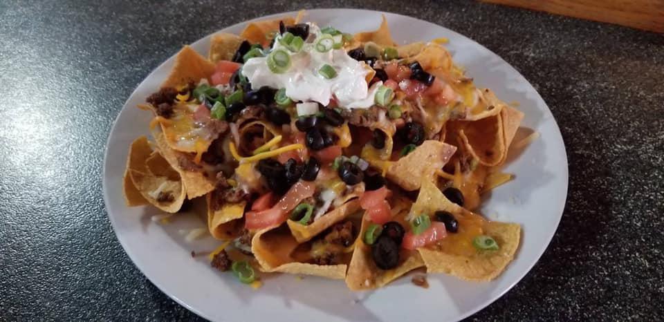 Grande Nachos · Fresh tortilla chips topped with house refried beans, queso, black olives, tomatoes and green onions. Served with salsa and sour cream.