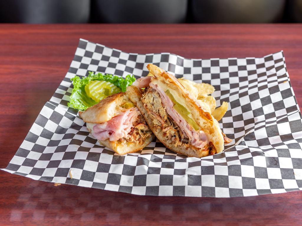The Cubano Sandwich · Smoked pulled pork shoulder, thin sliced smoked pit ham, melted Swiss cheese, dill pickles, and Dijon mayonnaise all stuffed into a toasted ciabatta roll.